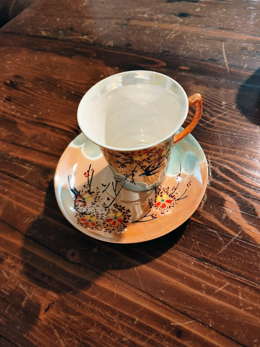 Porcelain Teacup and Saucer with Orange Handle and Floral Bird Motif
